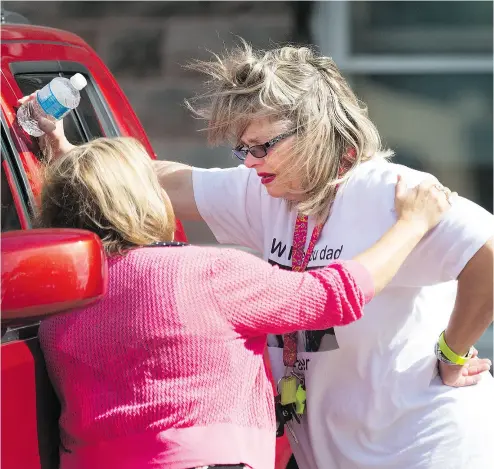  ?? PETER POWER / THE CANADIAN PRESS ?? Susan Horvath, daughter of Arpad Horvath Sr., one of former nurse Elizabeth Wettlaufer’s victims, is comforted outside the courthouse in Woodstock on Thursday after the video confession given about her father’s murder.