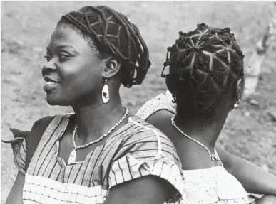 ??  ?? Community rituals Nigerian women await the visit of Queen Elizabeth II in 1956. Emma Dabiri draws on her own experience as a mixed-race Irish-Nigerian woman to tell a wide-ranging story of black hair