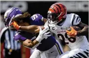  ?? ANDREW SOUFFLE / STAR TRIBUNE VIA AP ?? Bengals running back Joe Mixon knocks the helmet off Minnesota Vikings middle linebacker Eric Kendricks last Sunday in Cincinnati.