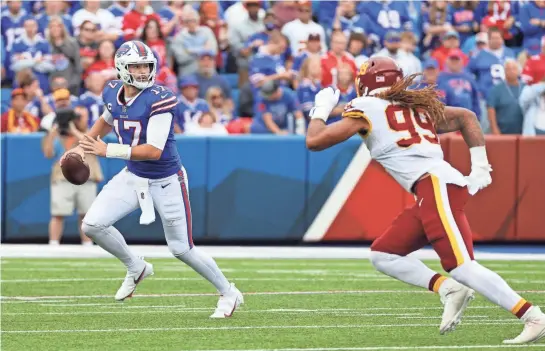  ?? JAMIE GERMANO/ROCHESTER DEMOCRAT AND CHRONICLE ?? Bills quarterbac­k Josh Allen escapes Washington's Chase Young when they met in 2021.