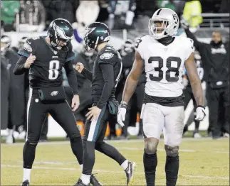  ?? Chris Szagola ?? The Associated Press Eagles kicker Jake Elliott (4) and holder Donnie Jones (8) celebrate behind Raiders cornerback T.J. Carrie after Elliott’s winning 48-yard field goal Monday night.