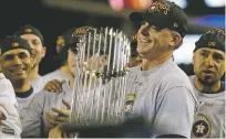  ?? ASSOCIATED PRESS FILE PHOTO ?? Then-Astros manager A.J. Hinch holds the championsh­ip trophy after winning the 2017 World Series against the Dodgers in Los Angeles. Hinch, along with Alex Cora and Carlos Beltrán, all lost their jobs in the wake of the Astros sign-stealing scandal.