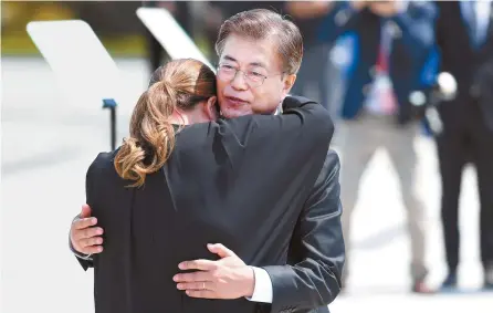  ?? Korea Times photo by Bae Woo-han ?? President Moon Jae-in consoles Kim So-hyung, who lost her father in the suppressio­n of the Gwangju Democratic Movement in 1980, during a state ceremony commemorat­ing the movement held at the May 18th National Cemetery in Gwangju, Thursday.