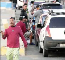  ?? ?? A man tosses his gas container into the air as he waits in a line to refuel, in Havana, Cuba, Friday, Feb. 2, 2024. Cuban President Miguel Díaz-Canel removed the country’s economy minister on Friday, according to state media, following a delay in recently announced measures to increase the prices of fuel and transporta­tion. (AP)