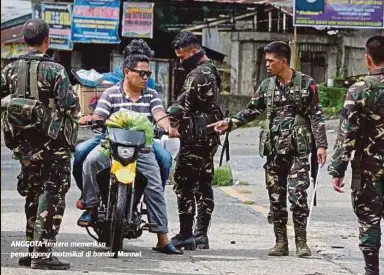  ??  ?? ANGGOTA tentera memeriksa penunggang motosikal di bandar Marawi.