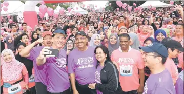  ??  ?? Ali Hamsa and his wife taking a welfie with Dr Noor Hisham and runners before flagging off Putrajaya Pink October Run 2017 at Dataran Putrajaya. — Bernama photo