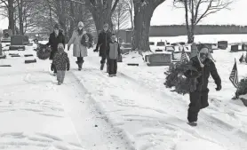  ?? MIKE MURPHY/MESSENGER POST MEDIA ?? In this file photo, youngsters and their families braved the snow and cold to help place wreaths on the graves of veterans in South Farmington Friends Cemetery.