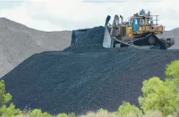  ?? MARK BAKER/AP 2021 ?? Coal is moved near Muswellbro­ok, Australia. In a first, the nation’s government recently rejected a coal mining applicatio­n based on environmen­tal law.