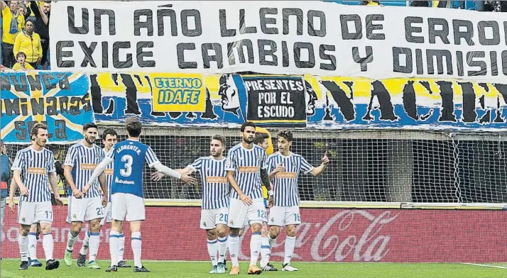  ?? FOTO: QUIQUE CURBELO (LA PROVINCIA) ?? Los jugadores de la Real celebran el gol de Oyarzabal ante una pancarta que refleja a la perfección el ambiente en el que les tocó jugar