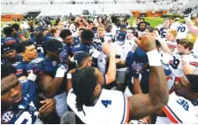  ?? AUBURN PHOTO BY TODD VAN EMST ?? Auburn football players surround first-year coach Bryan Harsin after Saturday’s A-Day game inside Jordan-Hare Stadium.