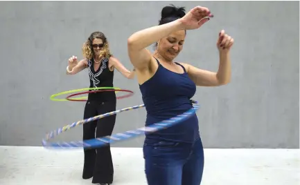  ?? (Gina Ferazzi/Los Angeles Times) ?? WHAM-O EMPLOYEES Nancy Nosko (left) and Tonya von Stenzsch try out the latest Hula Hoops.