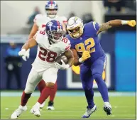  ?? Ashley Landis / Associated Press ?? New York Giants running back Devontae Booker (28) runs past Los Angeles Chargers defensive end Joe Gaziano during the second half on Sunday in Inglewood, Calif.