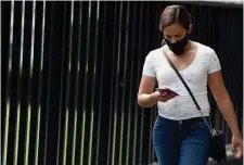  ?? Getty images ?? DOWNER: A woman checks her phone Monday in Mexico City. Facebook and its Instagram and WhatsApp platforms were hit with a massive outage that left them offline for much of the day.