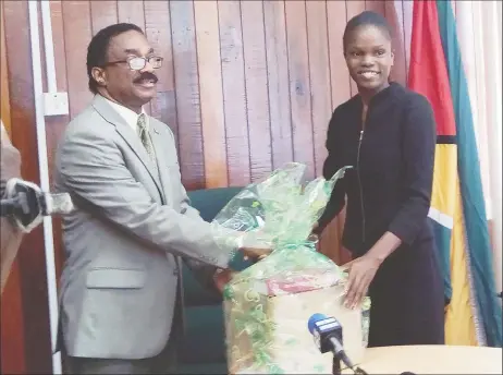  ??  ?? Attorney General Basil Williams SC hands over a collection of the Law Reports of Guyana to Latoya Roberts, the Best Graduating Guyanese student at the Hugh Wooding Law School for 2016.