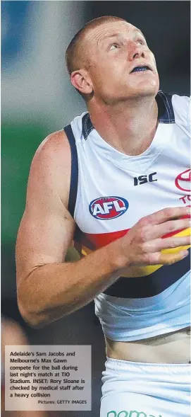  ?? Pictures: GETTY IMAGES ?? Adelaide’s Sam Jacobs and Melbourne’s Max Gawn compete for the ball during last night’s match at TIO Stadium. INSET: Rory Sloane is checked by medical staff after a heavy collision