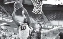  ?? STAFF PHOTO BY ROBIN RUDD ?? UTC’s James Lewis Jr. shoots in front of VMI’s Tyler Creammer.