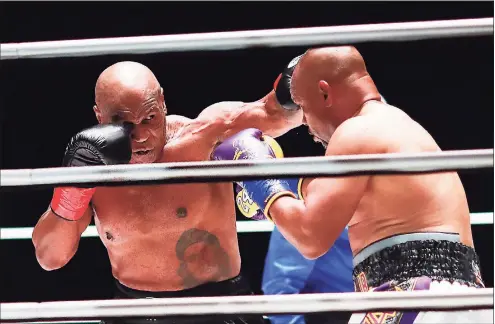  ?? Joe Scarnici / Associated Press ?? In a photo provided by Triller, Mike Tyson throws a punch during the third round against Roy Jones Jr. in an exhibition boxing bout Saturday.