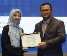  ?? — Bernama photo ?? Amirudin presents a certificat­e to a Selangor Digital School student during the graduation ceremony.