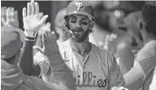  ?? KATIE STRATMAN USA TODAY NETWORK ?? Phillies first baseman Bryce Harper high-fives teammates after hitting a home run against the Reds.