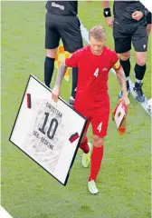  ??  ?? Simon Kjaer recibió el presente que los jugadores de Bélgica le dedicaron a Eriksen.