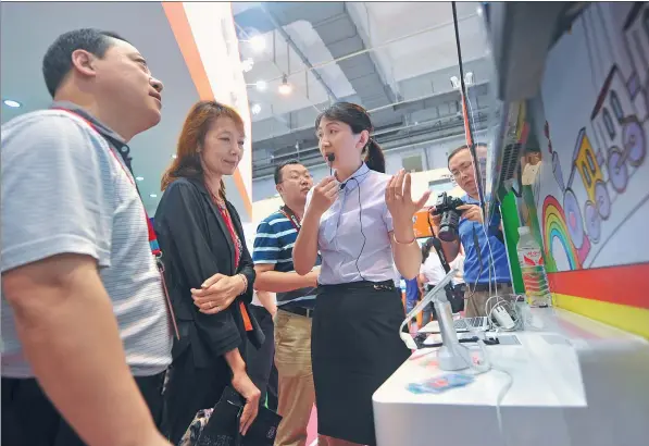  ?? WANG HAIBIN / FOR CHINA DAILY ?? A China Unicom employee introduces the company’s “internet plus education” app targeting children at an exhibition in Qingdao, Shandong province.