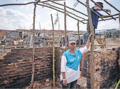  ?? Pictures: Jacques Nelles ?? STARTING OVER. Lucy Motloheloa, left, stands in what is left of her home in the Cemetery View informal settlement in Woodlands, Pretoria, yesterday.
GUTTED. Cemetery View informal settlement, below, in
Woodlands after being gutted by fire on Sunday.