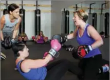  ?? MICHILEA PATTERSON — DIGITAL FIRST MEDIA ?? Boxing instructor Deanne Vanjonack, far left, coaches Julie Segrave-daly, center, and Tina Gibson, far right, during a boxing boot camp class at Ignite Fitness Studio in West Vincent. The class combined boxing combinatio­n with types of other exercises...