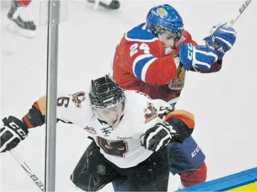  ?? SHAUGHN BUTTS/ EDMONTON JOURNAL ?? Mason Geertsen of the Edmonton Oil Kings checks the Calgary Hitmen’s Cody Sylvester during Friday’s WHL game at Rexall Place.