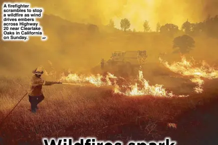  ?? AP ?? A firefighte­r scrambles to stop a wildfire as wind drives embers across Highway 20 near Clearlake Oaks in California on Sunday.