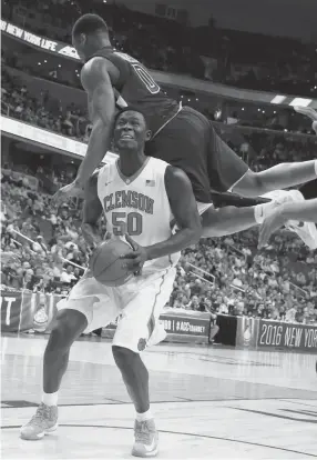  ??  ?? Clemson center Sidy Djitte is fouled by Georgia Tech forward Charles Mitchell during the second half of Wednesday’s basketball game in the Atlantic Coast Conference men’s tournament in Washington. Georgia Tech won 88-85 in overtime.