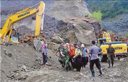 ?? AFP PIC ?? Search-and-rescue personnel recovering the body of a landslide victim in Magelang, Java, yesterday.