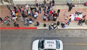  ?? (AP) ?? This file photo shows people waiting along the US-Mexico border in Tijuana, Mexico, to obtain asylum in the United States, on November 12