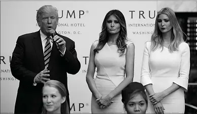  ?? Associated Press ?? Ivanka Trump, right, and Melania Trump, center, listen as then-Republican presidenti­al candidate Donald Trump speaks on Oct. 26, 2016, during the grand opening of the Trump Internatio­nal Hotel- Old Post Office in Washington.