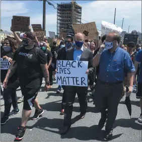  ?? MARK SCOLFORO - THE ASSOCIATED PRESS ?? Gov. Tom Wolf, holds a “black lives matter” sign while walking alongside Harrisburg Mayor Eric Papenfuse, right, marches with demonstrat­ors protesting police violence against black people and racial injustice following the killing of George Floyd, Wednesday, June 3, 2020in Harrisburg, Pa.