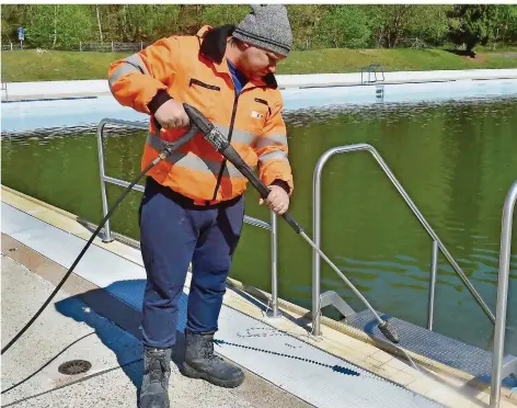  ?? FOTO: BECKER & BREDEL ?? Saisonvorb­ereitung im Dudweiler Freibad: Marc Karl von den Stadtwerke­n Saarbrücke­n reinigte am Dienstag mit einem Dampfstrah­ler den Beckenrand und die Außenanlag­e. Das saubere Wasser für den Badebetrie­b wird erst später eingefüllt.