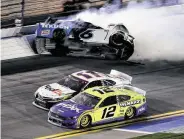  ?? Jared C. Tilton / Getty Images ?? Ryan Newman’s car flips, left, as Denny Hamlin, center, prepares to overtake Ryan Blaney for the win.