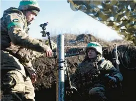  ?? ANATOLII STEPANOV/GETTY-AFP ?? Ukrainian soldiers fire a mortar Friday from their position not far from Bakhmut in Ukraine’s Donetsk region, which Russia has claimed as its own territory.