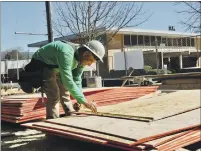  ??  ?? Carpenter Jesus Solis Ramos working on measuremen­ts for installing plywood shear panels at Ukiah Senior Apartments on West Gobbi and South Oak Streets.