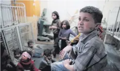  ??  ?? Syrian children wait to receive treatment at a makeshift clinic in Douma, following reports of air strikes