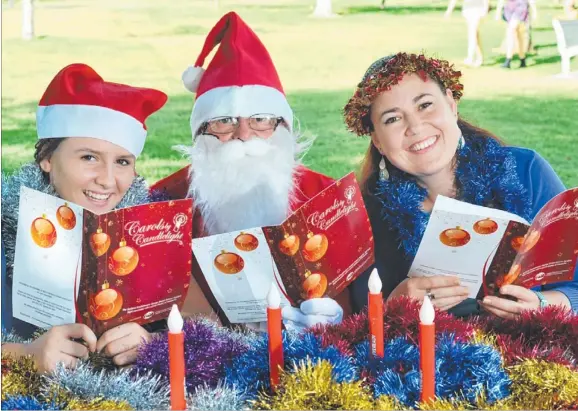  ?? Picture: KATRINA BRIDGEFORD ?? Jamie McPhee, Mike Foley and Jackie Izod are ready for tonight’s Carols by Candleligh­t at the Botanic Gardens