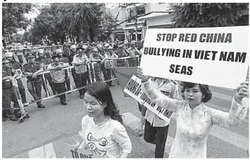  ??  ?? Vietnamese protest outside the Chinese Embassy in Hanoi, Vietnam against Beijing’s deployment of an oil rig in the contested waters of the South China Sea.