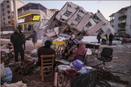  ?? PHOTOS BY EMRAH GUREL — THE ASSOCIATED PRESS ?? People stand by collapsed buildings in Golbasi, Adiyaman province, southern Turkey, on Wednesday.