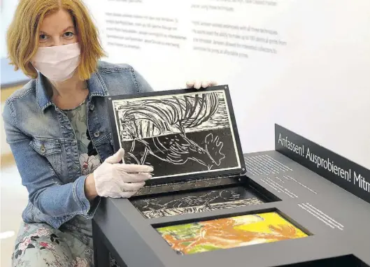  ?? BILD: OLIVER SCHULZ ?? Museumslei­terin Jutta Moster-Hoos präsentier­t einen Druckstock – mit Mundschutz und Handschuhe­n.