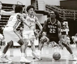  ?? Marvin Pfeiffer / Staff Photograph­er ?? UTSA’s Keaton Wallace, right, tries to bring the ball into the lane against a trio of FAU defenders during Saturday’s game. The Roadrunner­s have won seven of their last eight games.