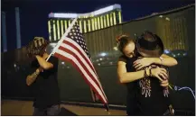  ?? THE ASSOCIATED PRESS FILE ?? Megan Murphy, at right in hat, embraces Cara Knoedler as Kenneth Wright wipes his eyes on the first anniversar­y of the 2017mass shooting in Las Vegas.