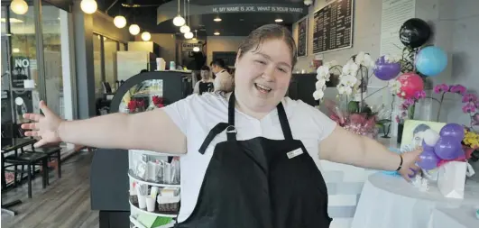  ?? WAYNE LEIDENFROS­T/ PNG ?? Frances Cooper loves her job at Joe’s Table Cafe in Burnaby, especially making lattes because they ‘ taste so awesome.’ The café — founded in the memory of Joseph Chung by his parents, Peter and Stephanie — goes the extra distance to provide work for...