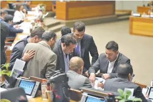  ??  ?? El titular de la Cámara de Diputados Pedro Alliana (ANR, cartista) dialoga con el líder de su bancada, Basilio Núñez, mientras otros legislador­es los observan.