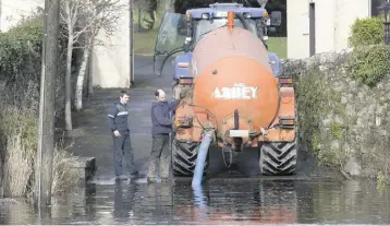  ?? ALF HARVEY ?? CLEARING UP: Keith Keane and Paddy Brennan working for John Tynan drawing water to wash beet from the flooded river Erkina at Durrow, Co Laois