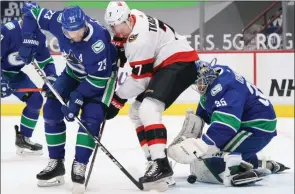  ??  ?? The Canadian Press
Vancouver Canucks defenceman Alexander Edler tries to clear Ottawa Senators’ Brady Tkachuk from in front of goaltender Thatcher Demko in Vancouver, Wednesday.
