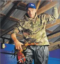  ?? ELIZABETH PATTERSON/CAPE BRETON POST ?? Roger Penny, son of Marlene Brogan, Ballast Ground Fisheries manager, shows one of the larger lobsters that will be sold for someone’s dinner.